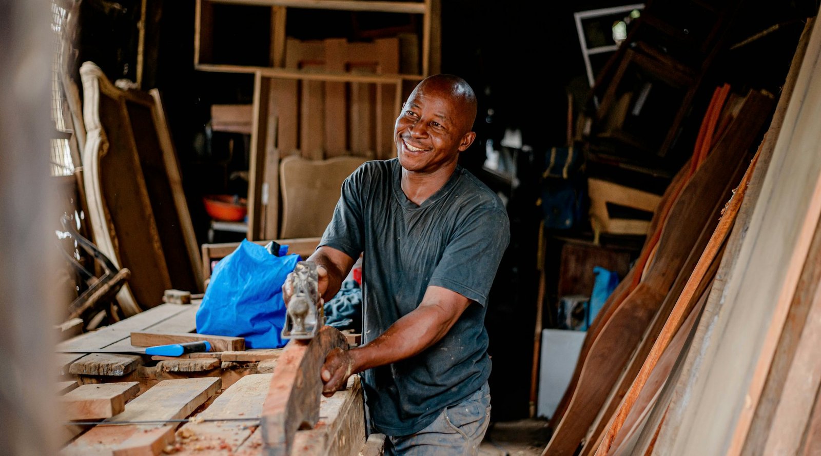 A joiner working a length of timber at the bench
