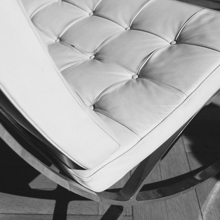 A detail of a tufted upholstered chair