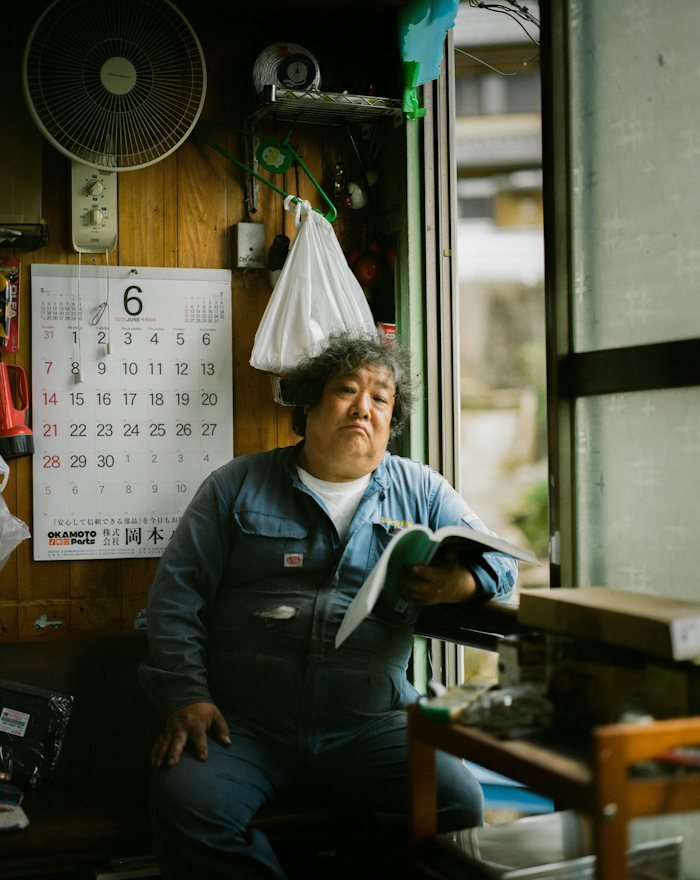 A maker in workshop overalls